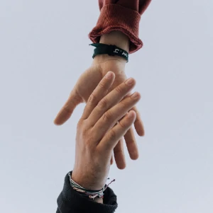 zwei Hände reichen sich die Hand, ein Symbol für Hilfe